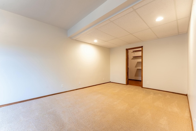 carpeted spare room featuring a drop ceiling