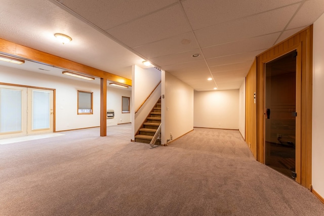 basement with a drop ceiling and light colored carpet