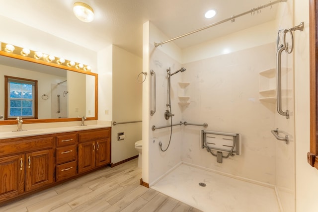 bathroom with walk in shower, hardwood / wood-style floors, vanity, and toilet