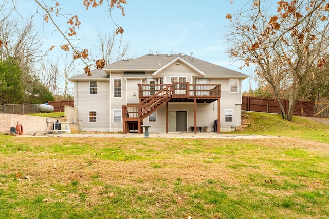 back of property with a yard and a wooden deck