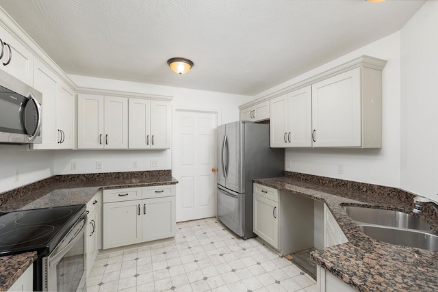 kitchen featuring stainless steel appliances, white cabinetry, and sink