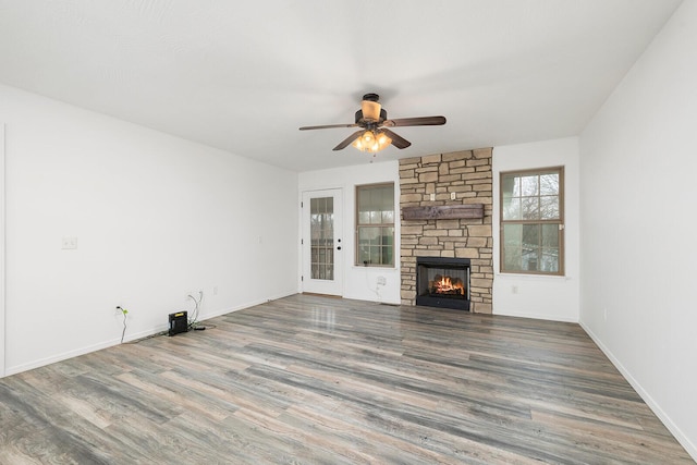 unfurnished living room with ceiling fan, a fireplace, and hardwood / wood-style flooring