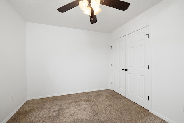 carpeted spare room with ceiling fan