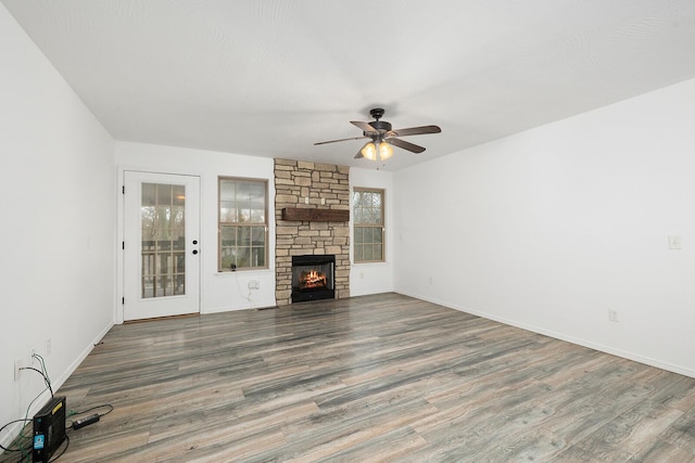 unfurnished living room featuring ceiling fan, a fireplace, and hardwood / wood-style floors