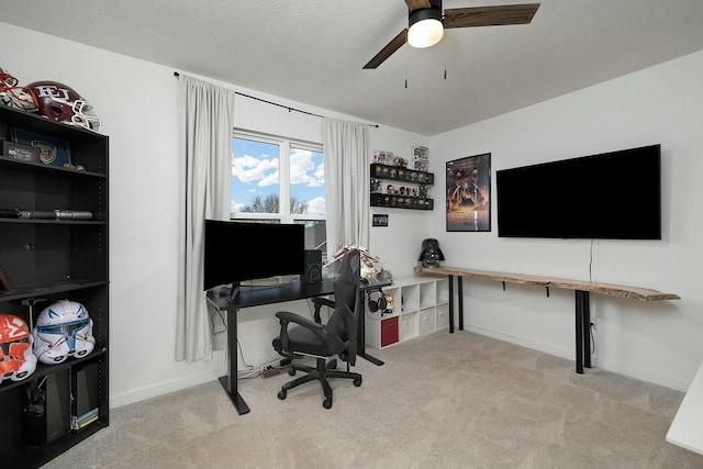 carpeted office space featuring ceiling fan and a textured ceiling