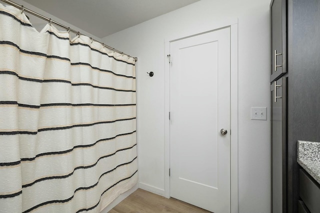 bathroom featuring curtained shower and wood-type flooring