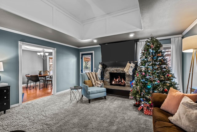 sitting room featuring carpet flooring, crown molding, a fireplace, and an inviting chandelier