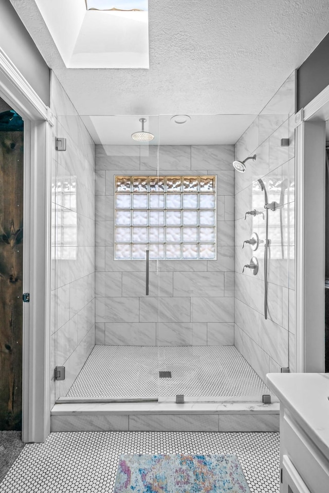 bathroom with a textured ceiling, vanity, and an enclosed shower