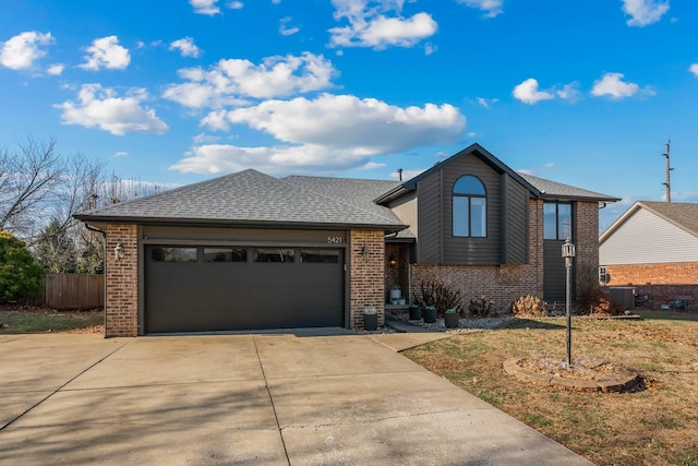 view of front of property with a front yard, a garage, and central AC unit