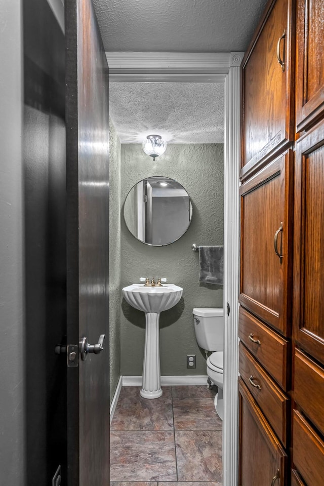 bathroom with a textured ceiling and toilet