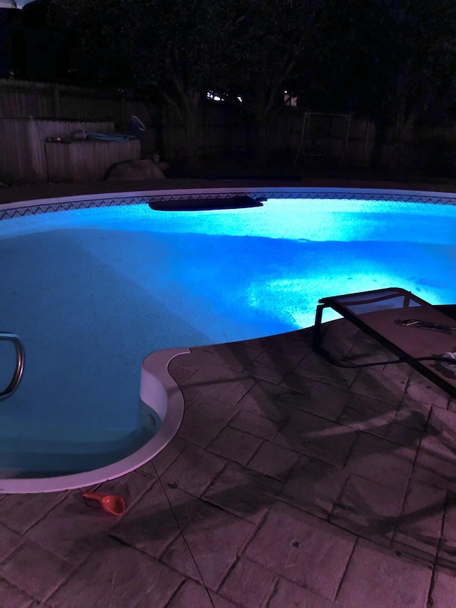 view of pool at twilight