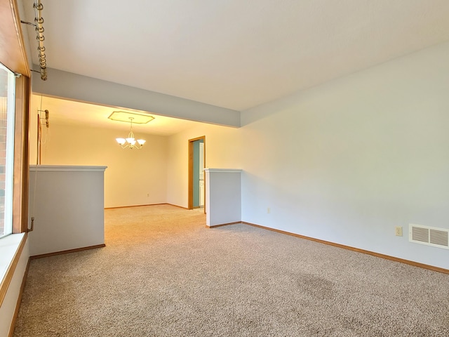 unfurnished room with a chandelier and light carpet