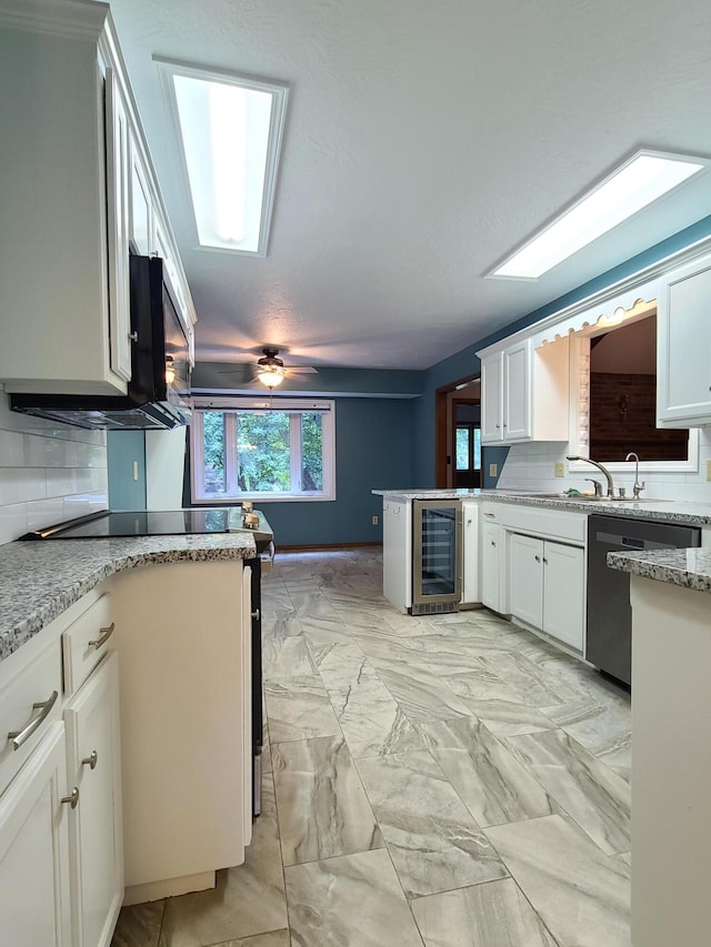 kitchen featuring white cabinets, dishwasher, beverage cooler, and backsplash