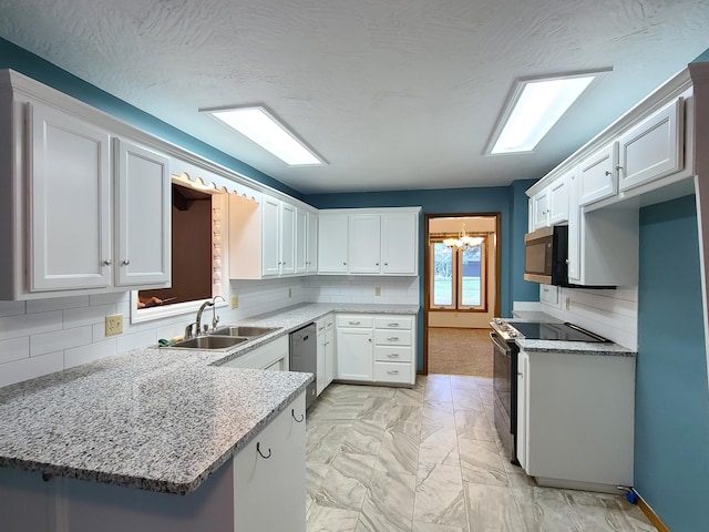 kitchen featuring sink, kitchen peninsula, white cabinets, stainless steel appliances, and backsplash