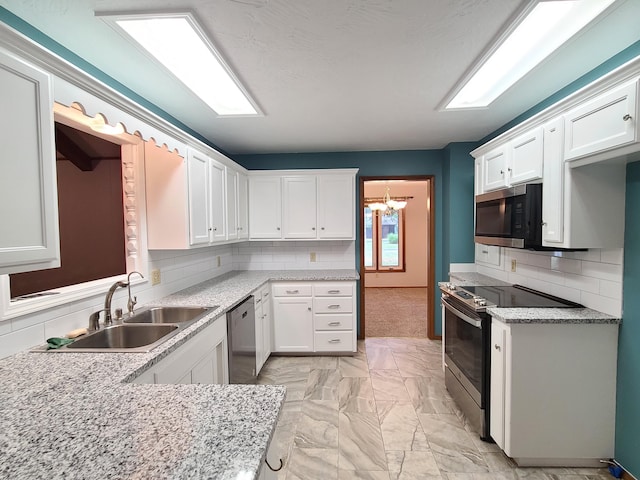 kitchen with white cabinetry, sink, decorative backsplash, and stainless steel appliances