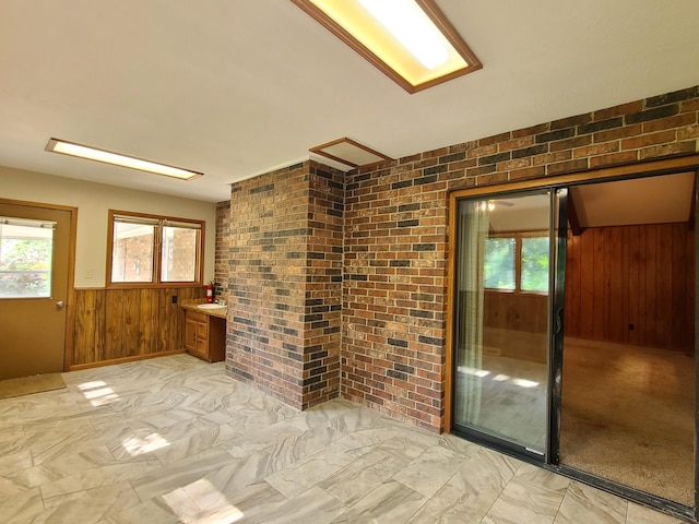 spare room featuring wooden walls and brick wall