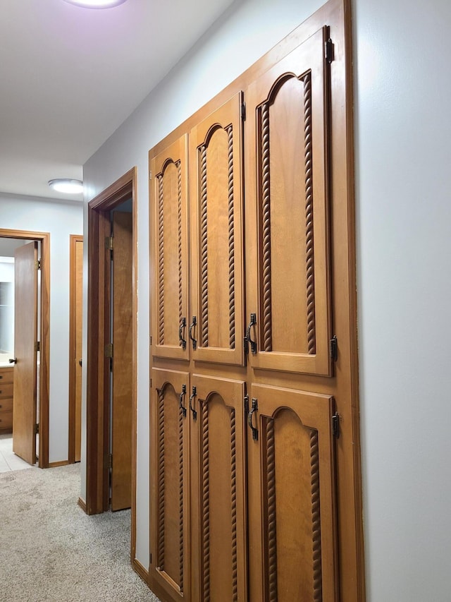 hallway featuring light colored carpet