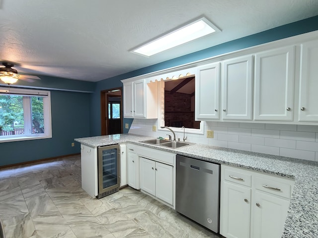 kitchen with sink, white cabinetry, wine cooler, stainless steel dishwasher, and kitchen peninsula