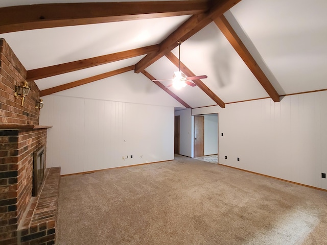 unfurnished living room featuring a fireplace, lofted ceiling with beams, ceiling fan, and carpet