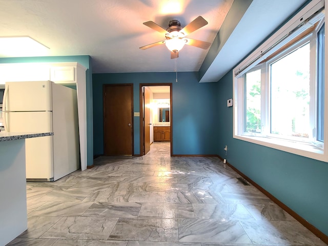 interior space featuring white cabinetry, ceiling fan, and white fridge