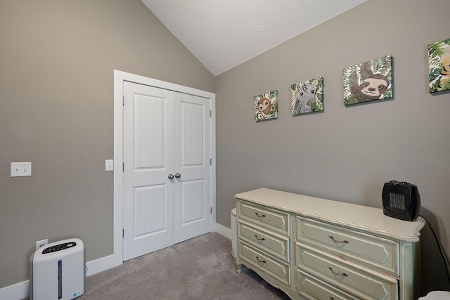 bedroom with a textured ceiling, a closet, light colored carpet, and vaulted ceiling