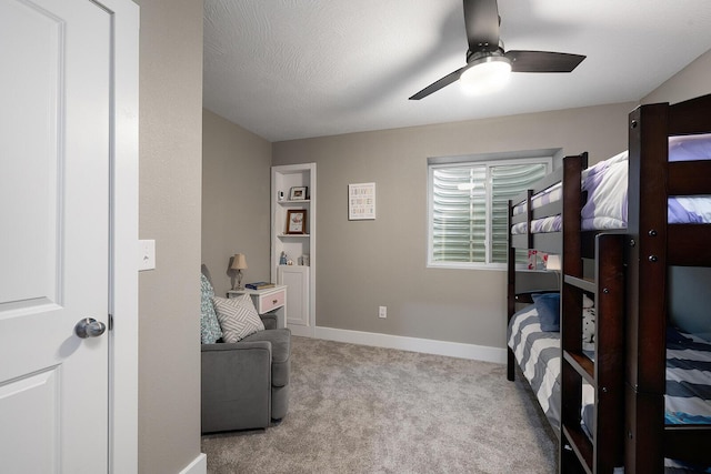 carpeted bedroom with ceiling fan and a textured ceiling