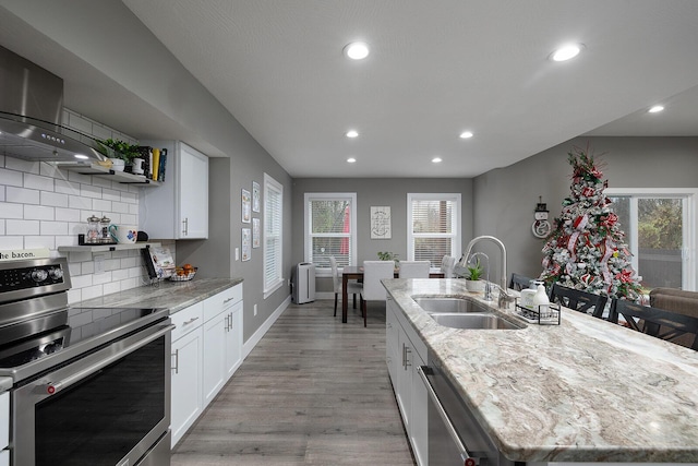 kitchen featuring sink, white cabinetry, stainless steel appliances, and an island with sink