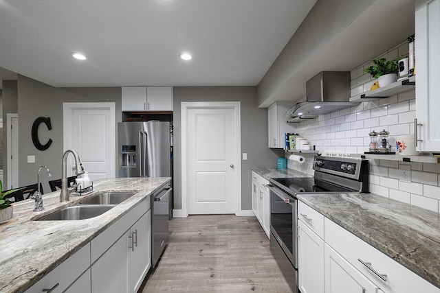 kitchen featuring white cabinets, appliances with stainless steel finishes, light stone counters, and sink