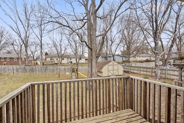 wooden terrace featuring a storage unit and a lawn