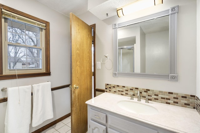 bathroom featuring walk in shower, tile patterned flooring, backsplash, a textured ceiling, and vanity