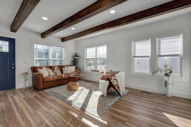 living room with light hardwood / wood-style flooring and beamed ceiling