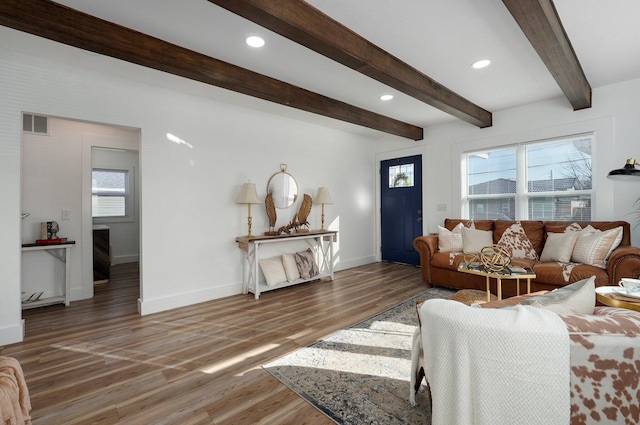 living room with dark hardwood / wood-style flooring and beamed ceiling