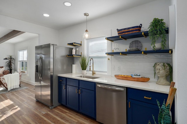 kitchen featuring blue cabinetry, sink, light wood-type flooring, and appliances with stainless steel finishes