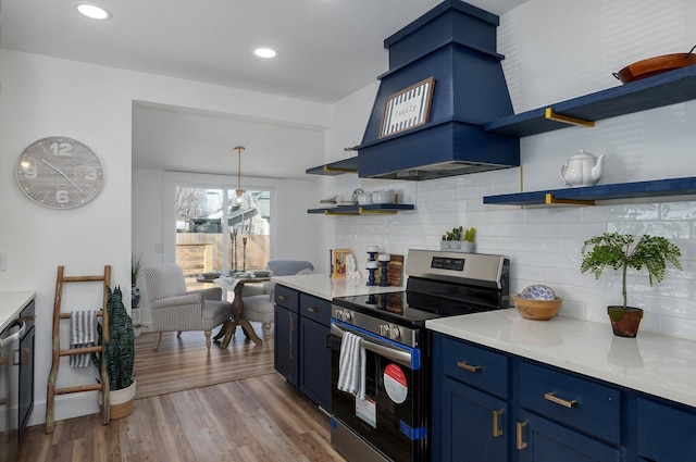 kitchen featuring light wood-type flooring, tasteful backsplash, blue cabinets, stainless steel electric stove, and hanging light fixtures