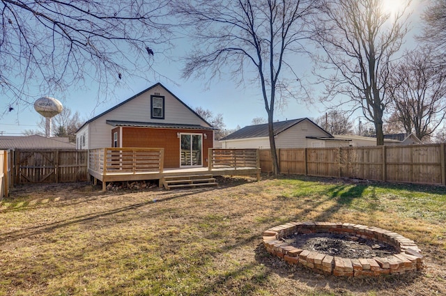 back of house featuring a lawn and a deck