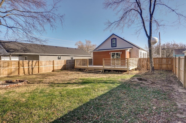 rear view of property featuring a yard and a deck