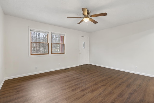 empty room featuring dark hardwood / wood-style flooring and ceiling fan