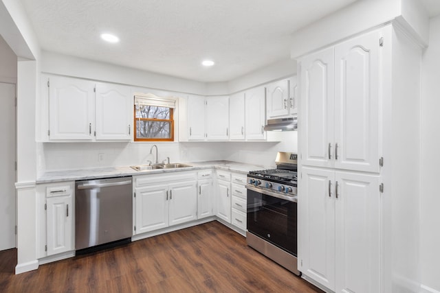 kitchen featuring dark wood-type flooring, sink, appliances with stainless steel finishes, tasteful backsplash, and white cabinetry