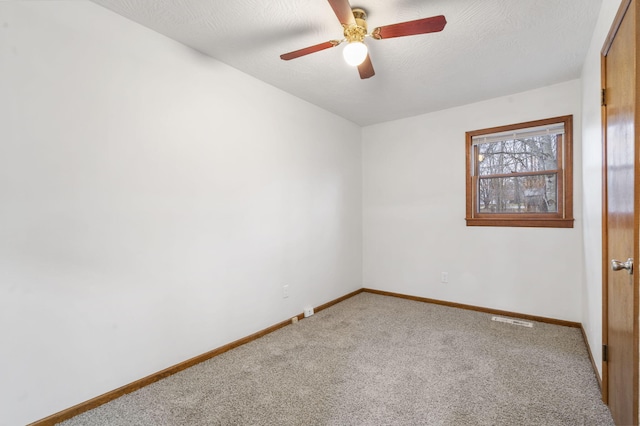 carpeted empty room with ceiling fan and a textured ceiling