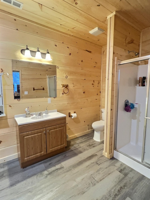 bathroom with vanity, wood-type flooring, walk in shower, and wooden walls