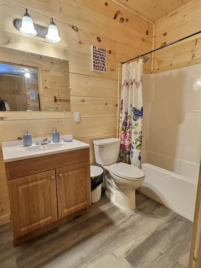 full bathroom with wood-type flooring, vanity, and wood walls