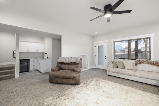 living room with ceiling fan, sink, light carpet, and beverage cooler