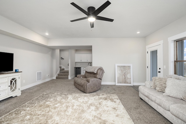 carpeted living room with ceiling fan