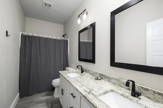 bathroom with a textured ceiling, vanity, toilet, and a shower with curtain