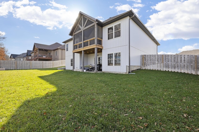 back of property featuring a sunroom and a lawn