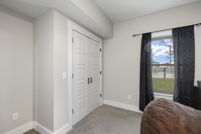 bedroom featuring multiple windows, light colored carpet, and a closet