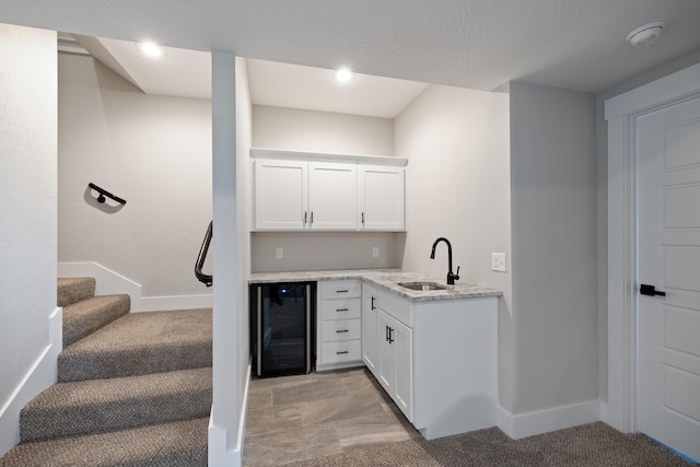 bar featuring white cabinets, light colored carpet, wine cooler, and sink