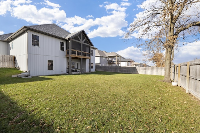 rear view of property with a yard and a sunroom