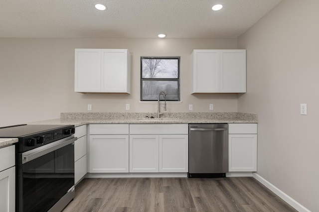 kitchen with sink, white cabinets, stainless steel dishwasher, and range