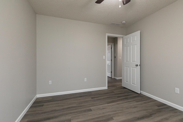 empty room featuring dark hardwood / wood-style floors, ceiling fan, and a textured ceiling